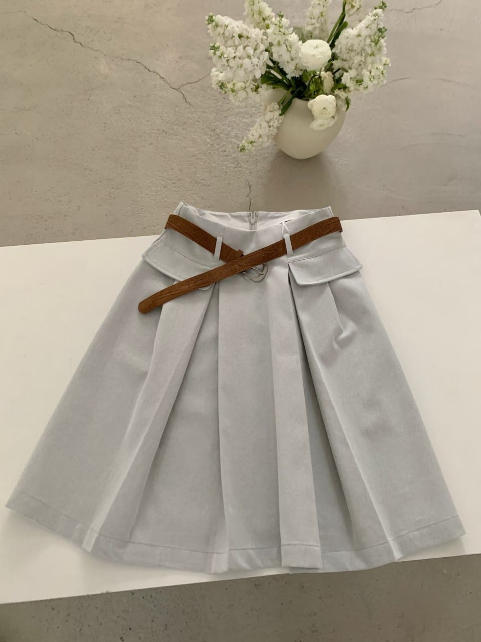 Light grey blue belted pleated mini skirt flat lay back view